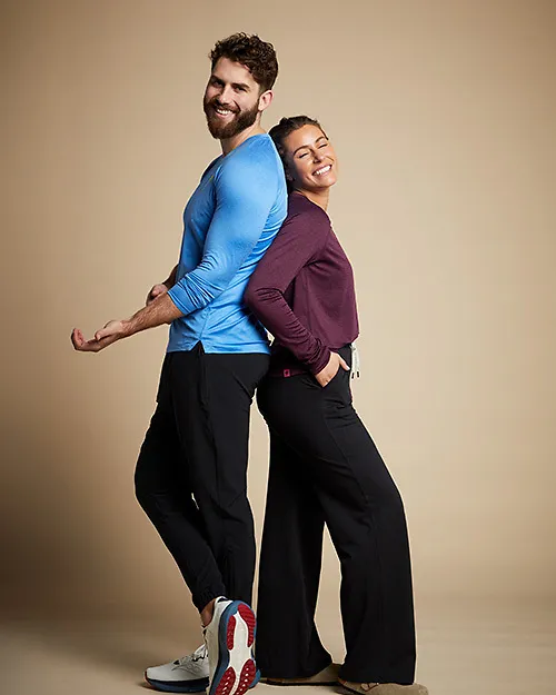 Man and woman standing back to back wearing running apparel