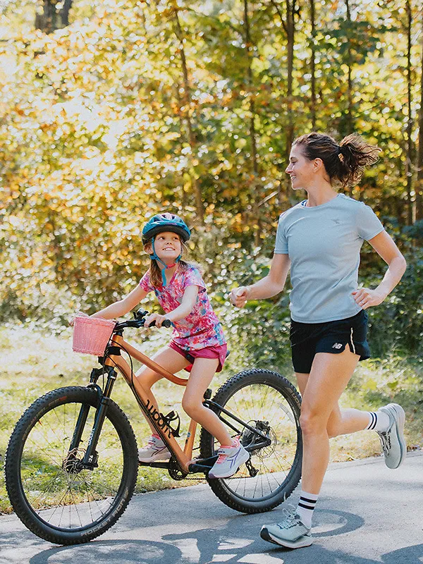 Mother running alongside daughter riding bike - mother’s day gifts for runners women