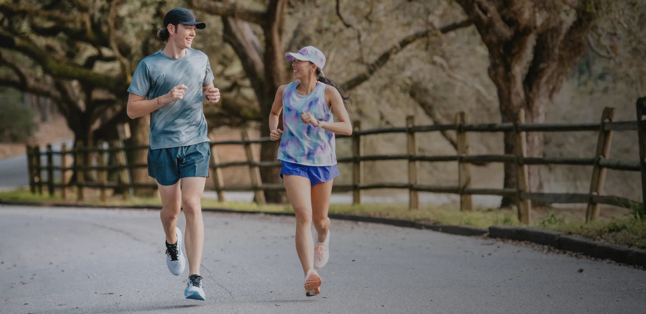 2 people running outside in the country while looking and smiling at each other